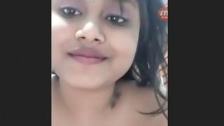 A stunning young woman showcases her large breasts