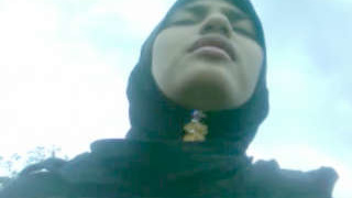 A charming girl wearing a hijab reveals her breasts and genitals