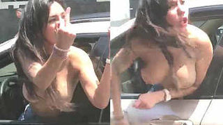 Wild woman goes topless and yells in a car on a busy street