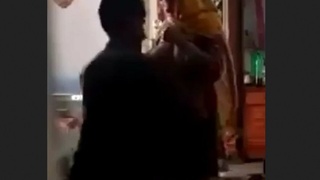 A seasoned pair indulges in a passionate rendezvous within their bedroom, featuring a mature Indian woman.