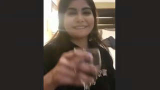 A seductive Pakistani escort reveals her breasts in a provocative display