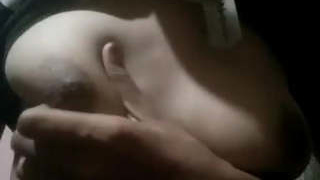 A woman from the Indian subcontinent squeezes her own breasts