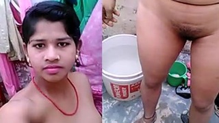 A rural woman undresses for a bath