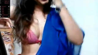 Indian girl with a slender figure performs on camera while wearing a traditional saree